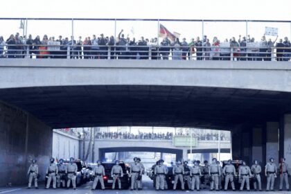 Thousands block major LA freeway, spray graffiti to protest Donald Trump's immigration crackdown